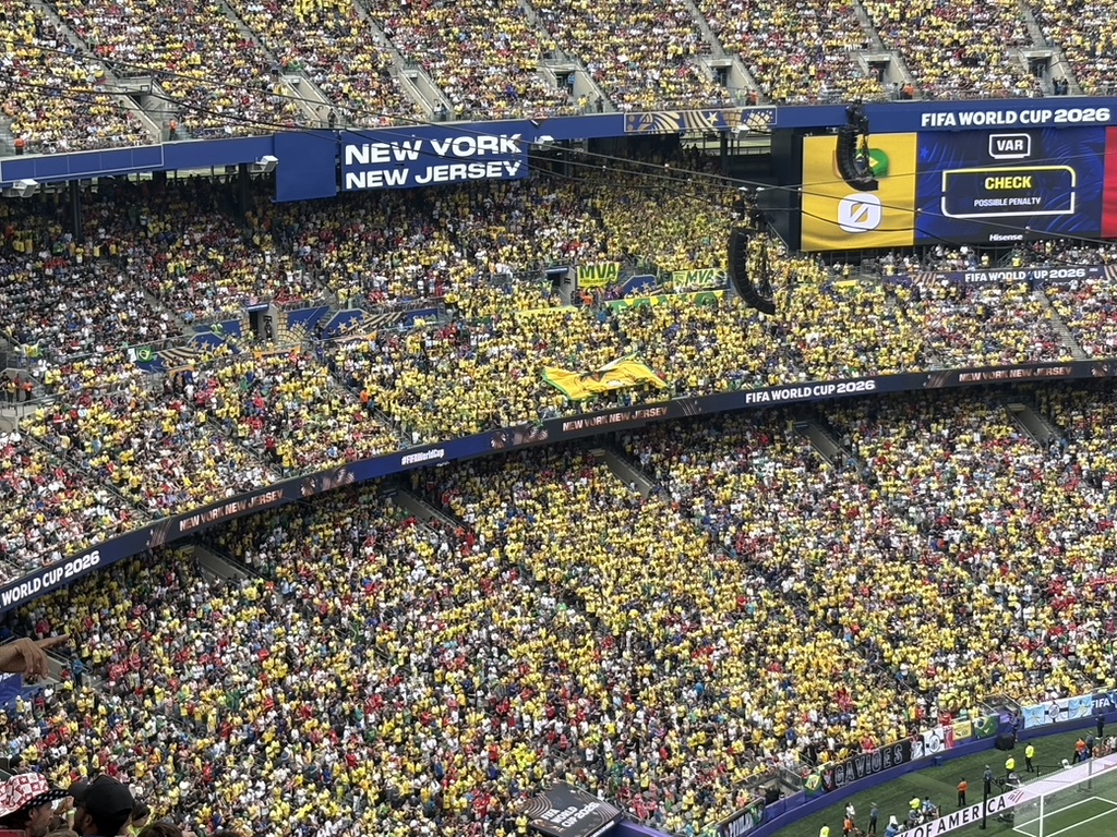 The Brazilian gallery during the VAR penalty check — a sea of yellow inside MetLife